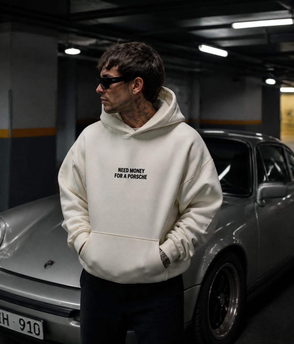 Person wearing the Need Money For A Porsche hoodie beside a silver Porsche 911